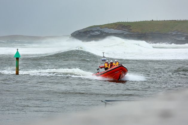 RNLI crew in Donegal rescue four people who became stranded at remote beach after boat overturned