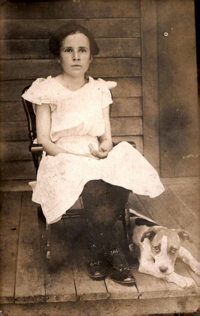 Solemn Young Girl with Her Dog (American 1910s)